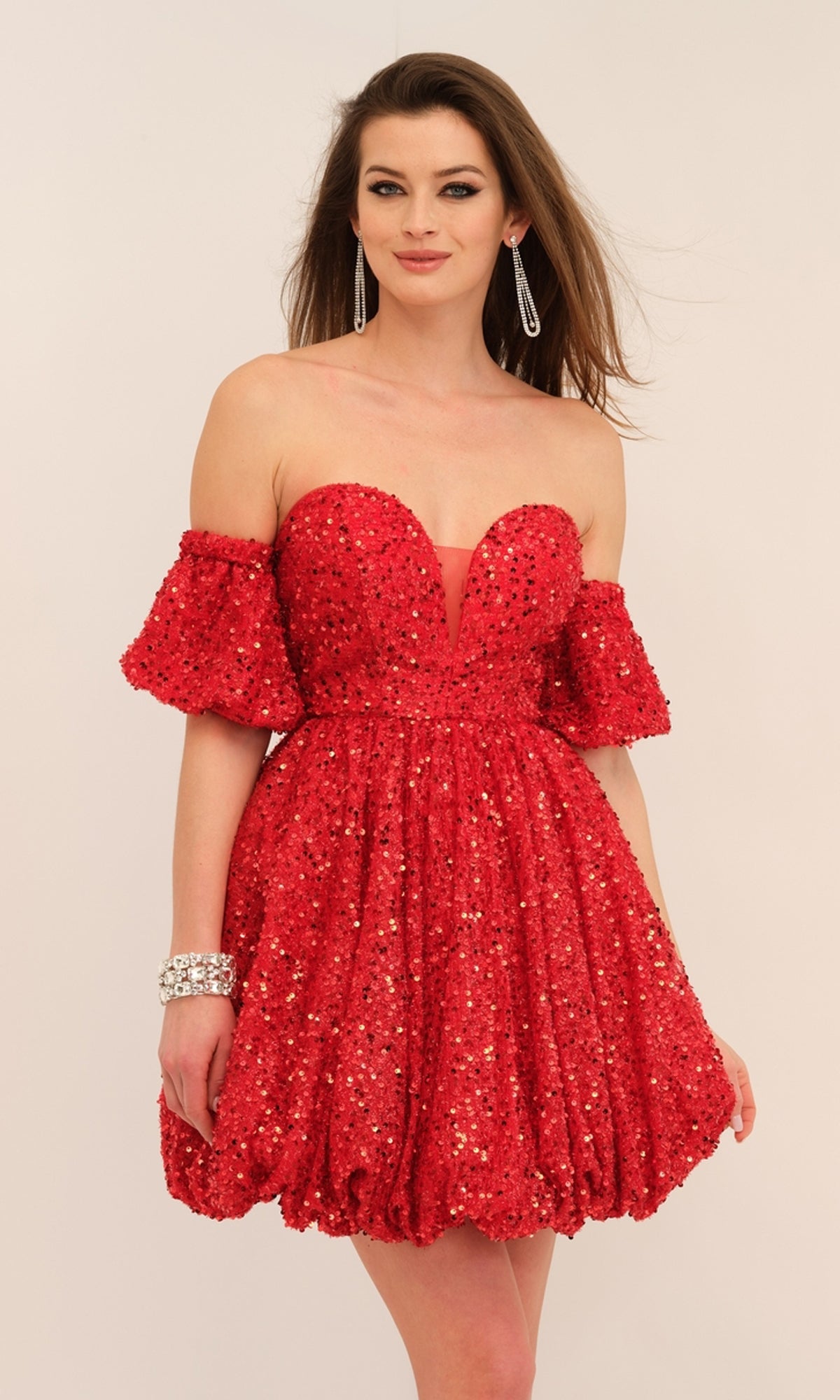 Model wears the Short-Sleeve Short Red Sequin Party Dress 11186 with drop earrings and a bracelet against a light background—the perfect homecoming dress choice.